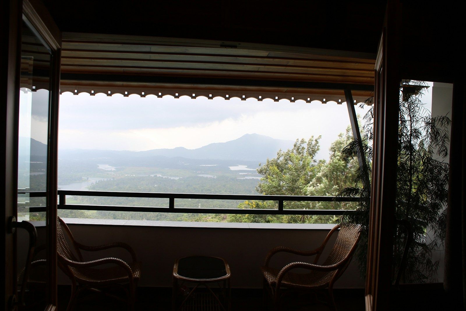 Balcony with two chairs looking out over green hills
