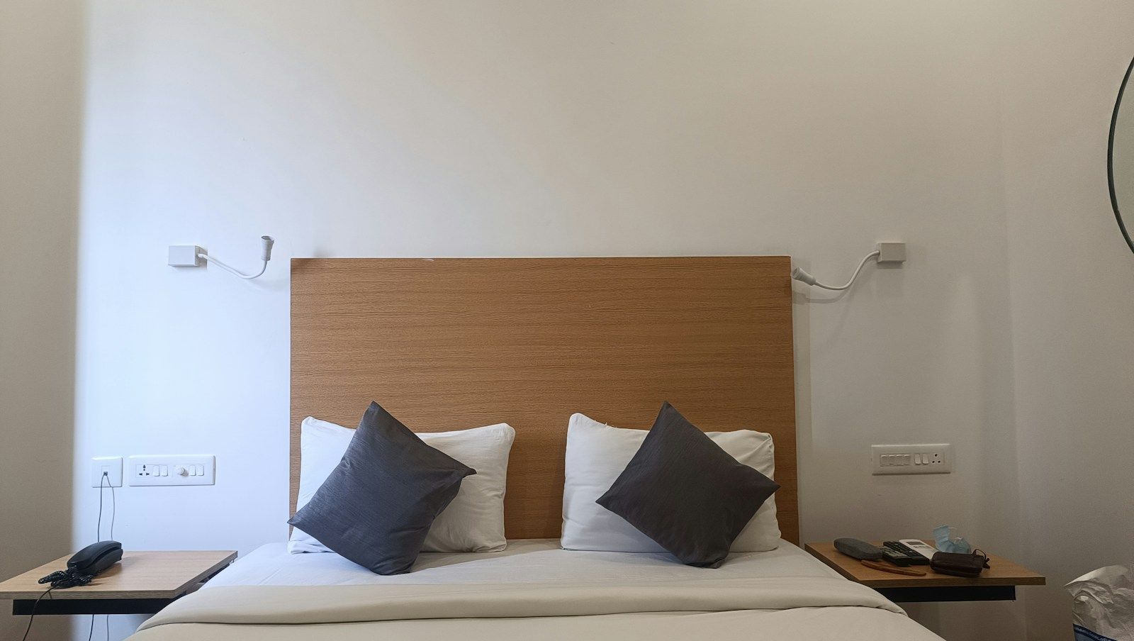 Simple bedroom with a wooden headboard and white bedding