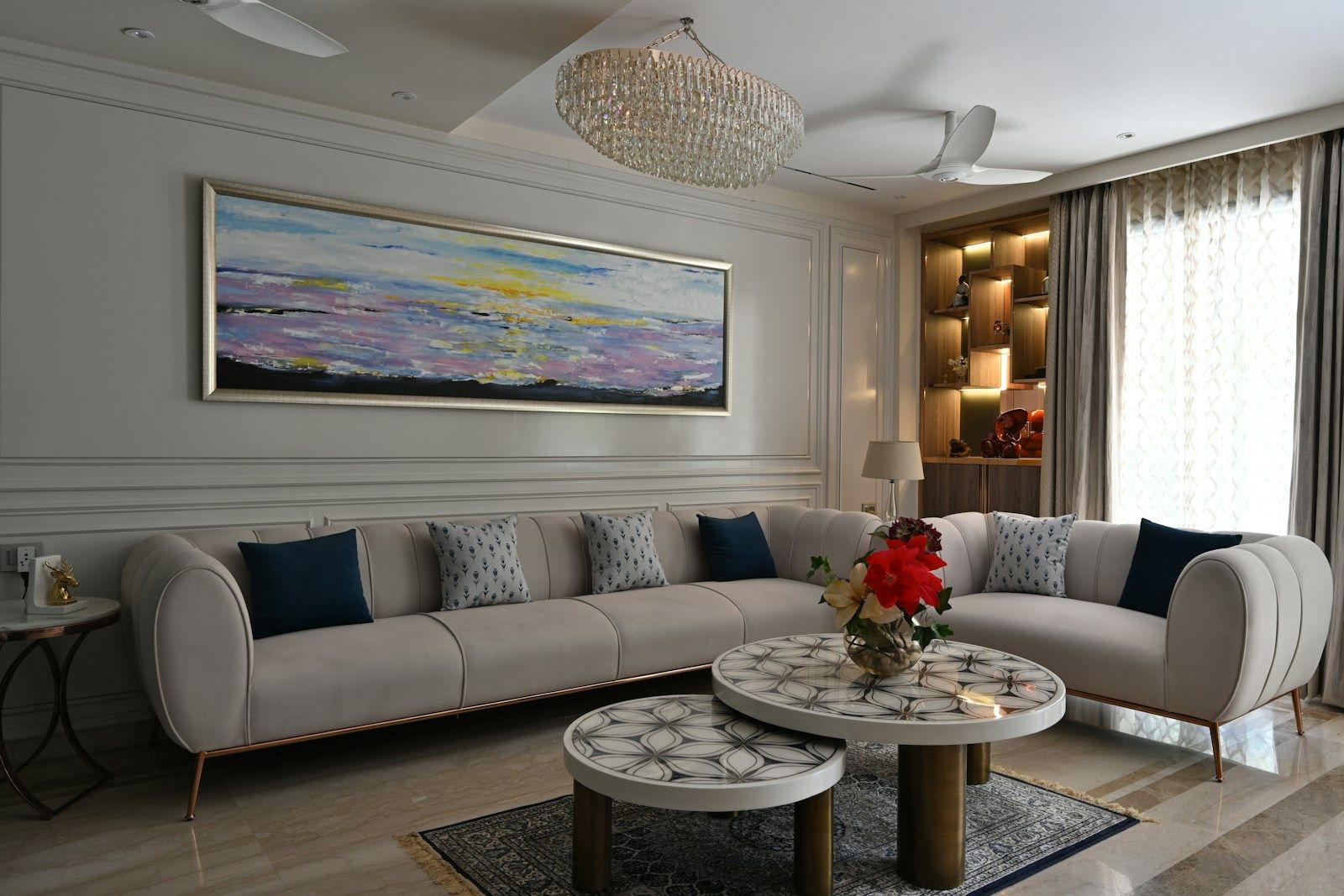 Living room with a curved white sofa and a painting above it