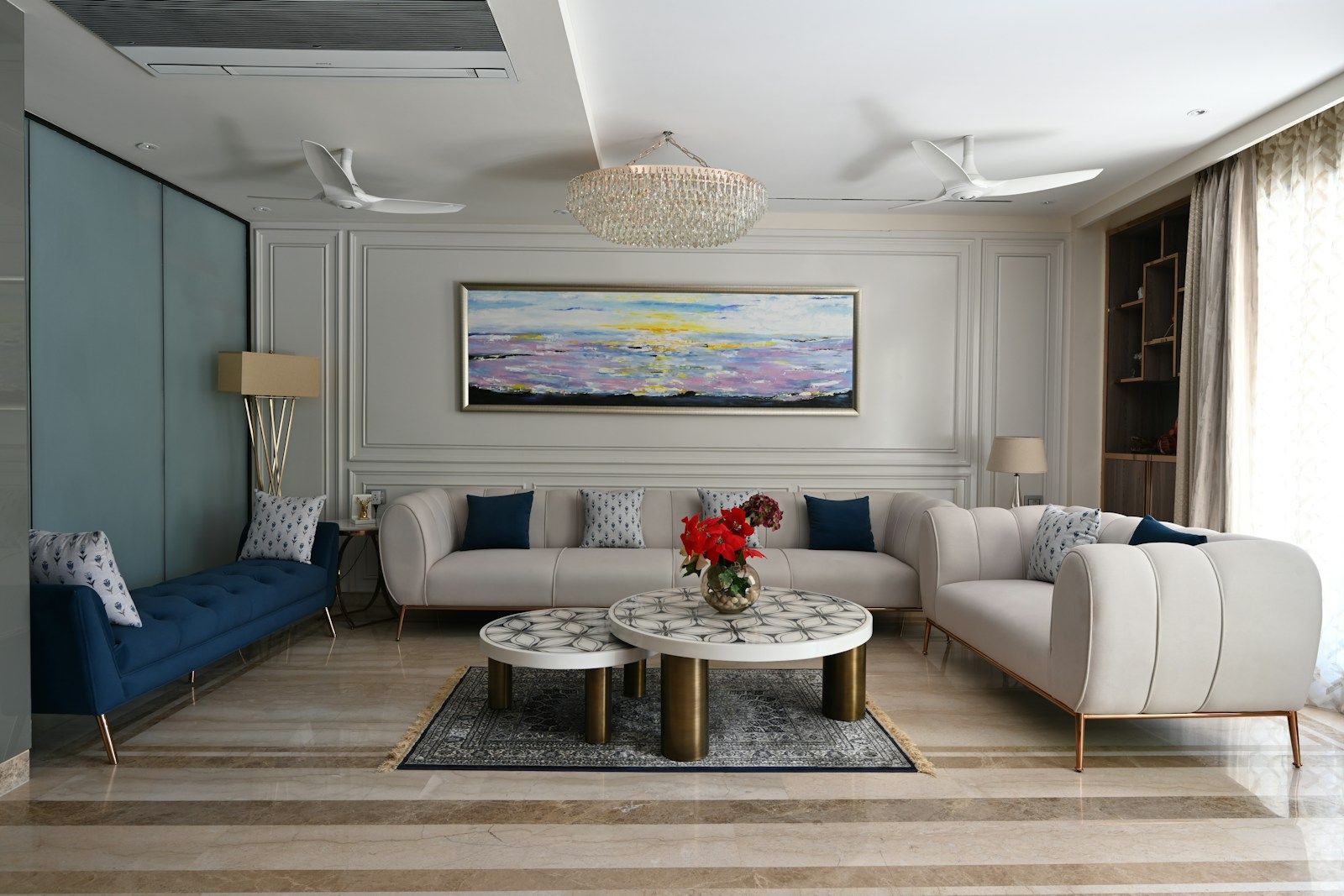Living room seen from the corner, with a blue armchair and white sofas