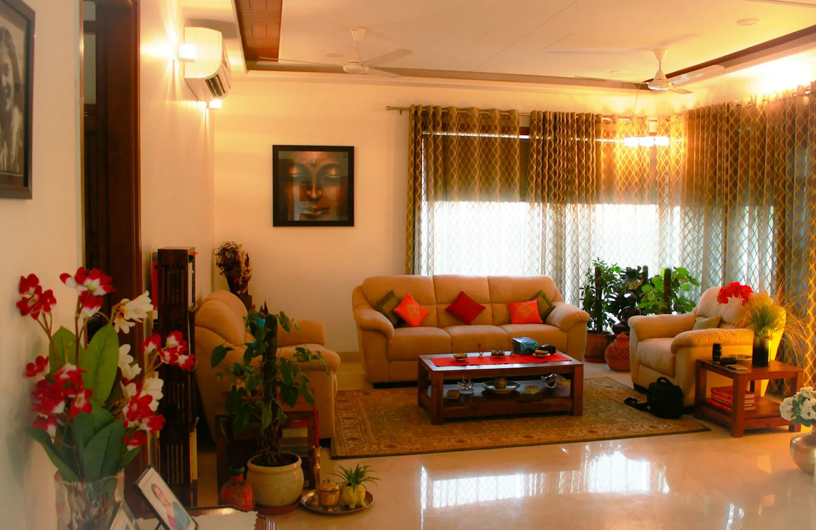 Bright living room with orange sofas, potted plants and a patterned rug